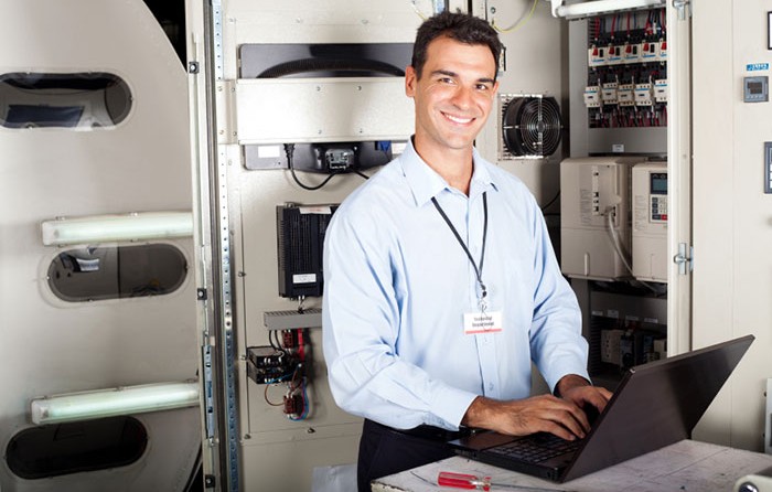 Man on a laptop infront of a machine